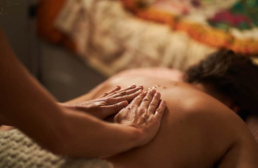 Masseur applying oil on back during relaxing massage therapy session Masaje relajante o descontracturante: cuál elegir según lo que necesita tu cuerpo